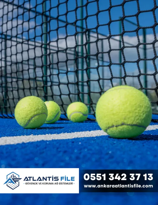 Tenis sahasında topları kontrol etmek için kullanılan siyah tenis filesi ve tenis topları